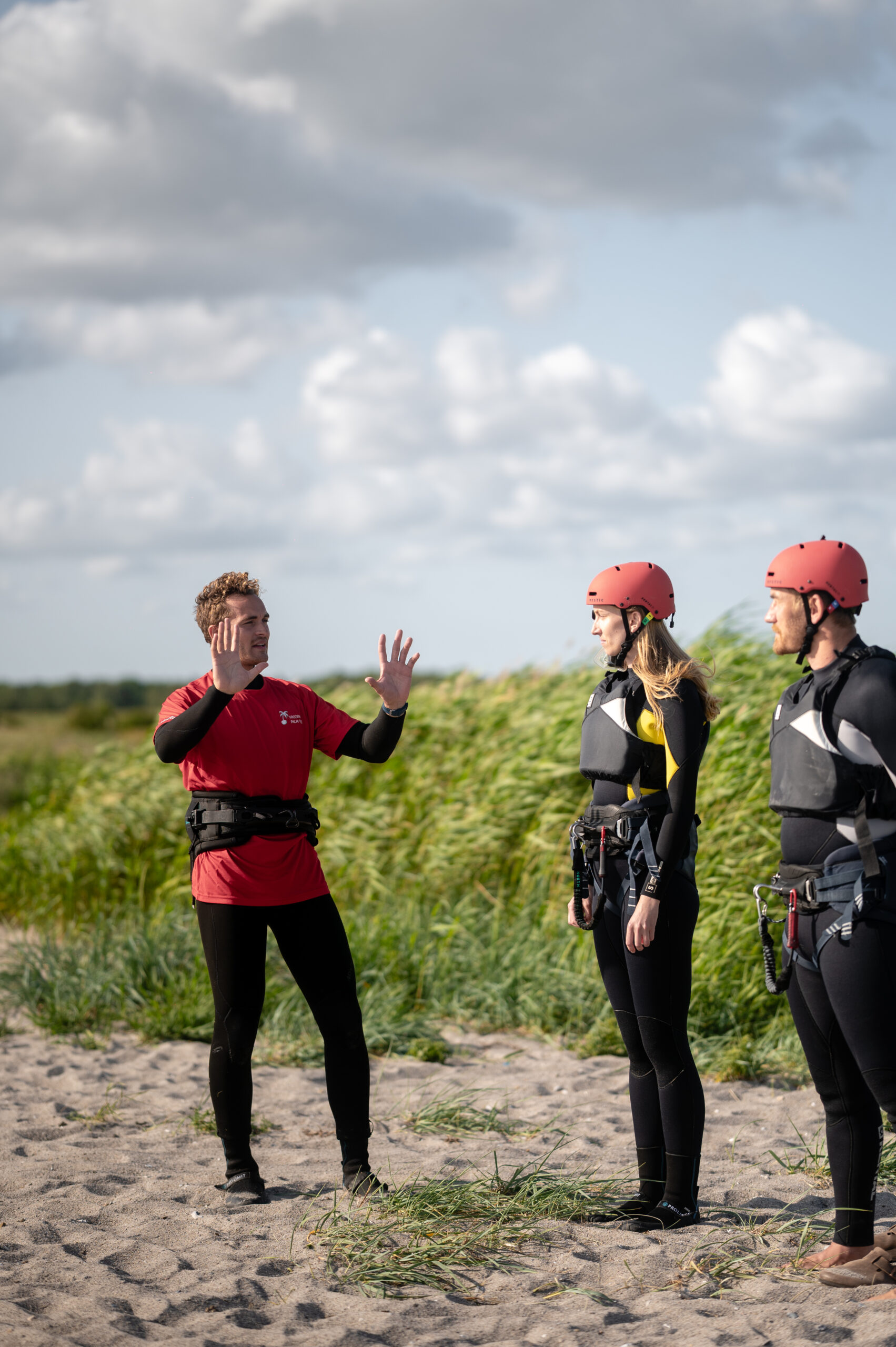 Instruktør underviser kitesurfelever på stranden
